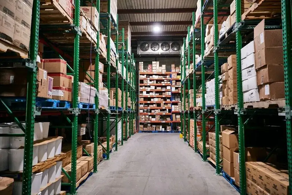 Spacious warehouse with organized metal shelving, efficient storage, and illuminated logistics environment.