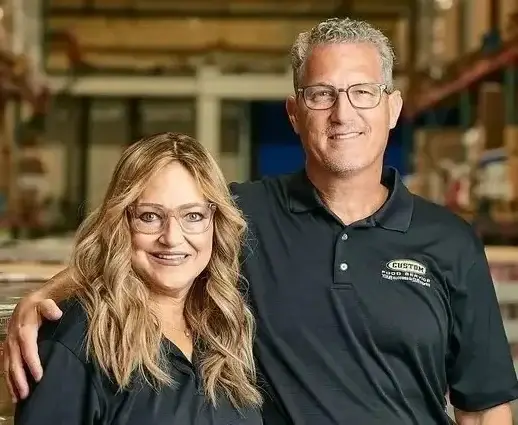 Professional teamwork in a well-organized warehouse, showcasing smiling colleagues in black polo shirts.